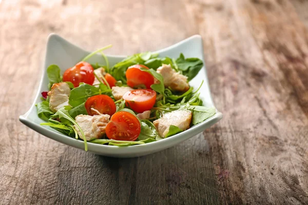 Cuenco con deliciosa ensalada de verduras sobre fondo de madera — Foto de Stock