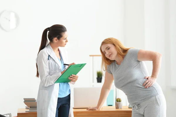 Jovem médica observando mulher com sobrepeso após o exercício na clínica — Fotografia de Stock