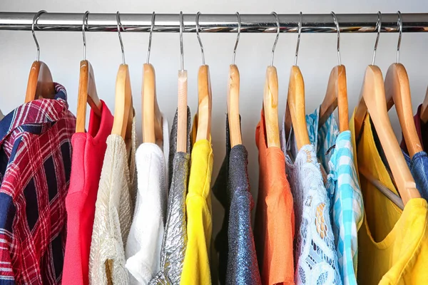 Colorful clothes on hangers in wardrobe — Stock Photo, Image