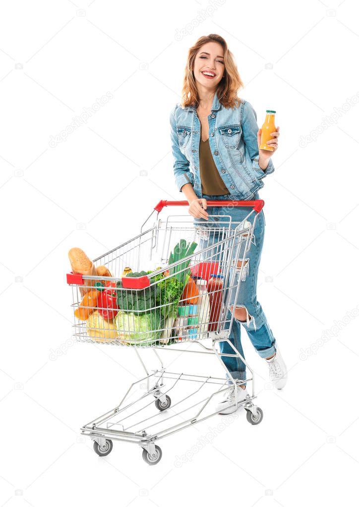 Young woman with full shopping cart on white background