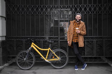 Çekici genç hipster fincan kahve ve şehir sokak bisiklet ile