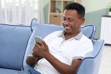 Olgun Afrikalı-Amerikalı adam cep telefonu evde kullanma