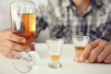 Şişe ve bardak brendi kapalı olan adam. Alkol bağımlılığı kavramı