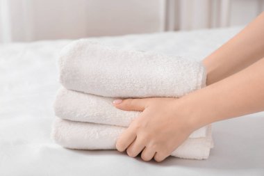 Havlu yığını yatağın üstüne koyarak kadın