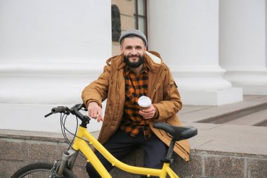 Çekici genç hipster fincan kahve ve şehir sokak bisiklet ile