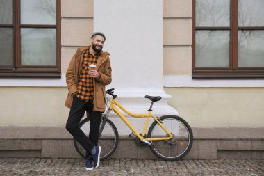 Çekici genç hipster fincan kahve ve şehir sokak bisiklet ile