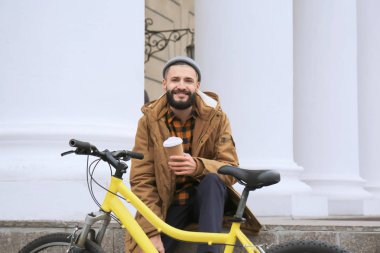 Çekici genç hipster fincan kahve ve şehir sokak bisiklet ile