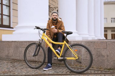 Çekici genç hipster fincan kahve ve şehir sokak bisiklet ile