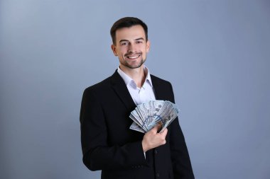 Gri arka plan üzerinde para ile resmi kıyafetli adam. Borsa broker