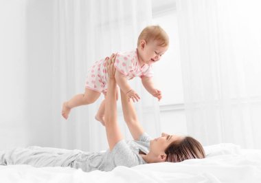 Genç Anne evde sevimli bebeğiyle oynuyor.