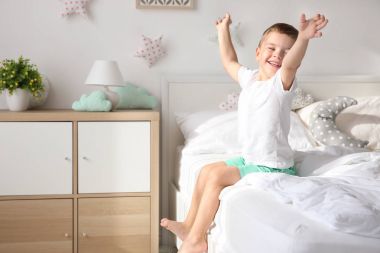 Evdeki yatakta tatlı küçük bir çocuk.