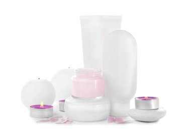 Farklı kozmetik ürünler ve beyaz zemin üzerine mumlar