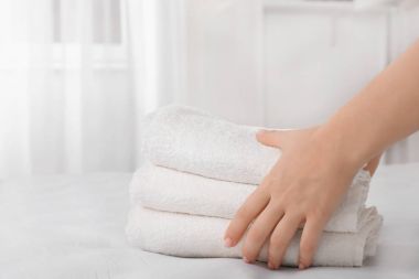 Havlu yığını yatağın üstüne koyarak kadın