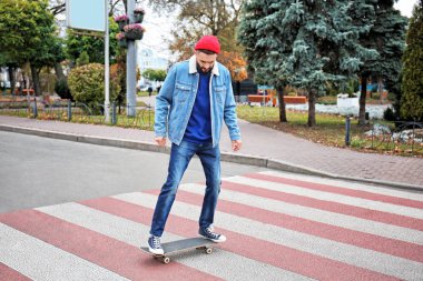 Çekici genç yenilikçi kaykay üzerinde şehir sokak sürme