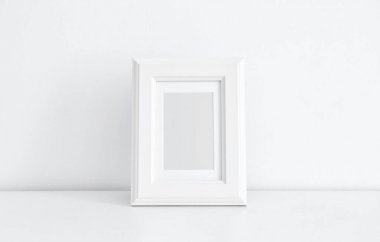 Beyaz duvar yakınındaki masada boş çerçeve