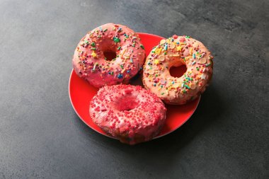 Plakalı gri arka plan üzerinde nefis renkli donut