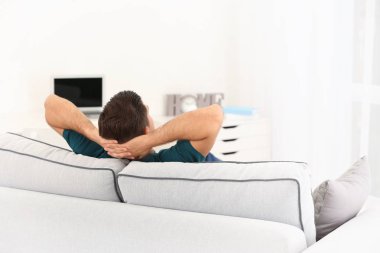 Yakışıklı adam evde koltukta dinleniyor