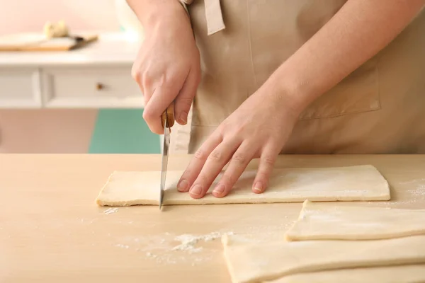 Woman cutting puff pastry on table — Stock Photo, Image