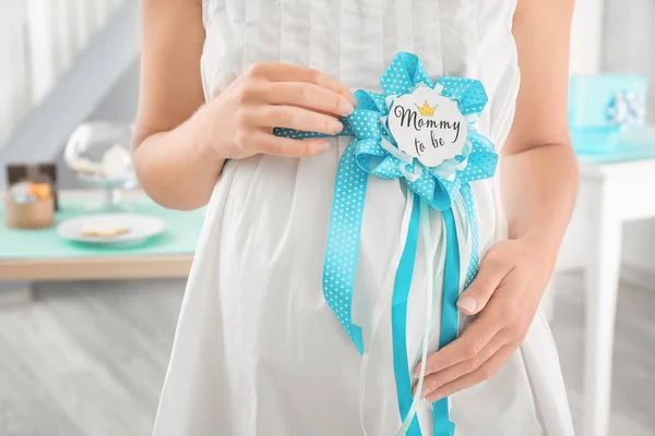 Pregnant woman with award ribbon on belly, closeup