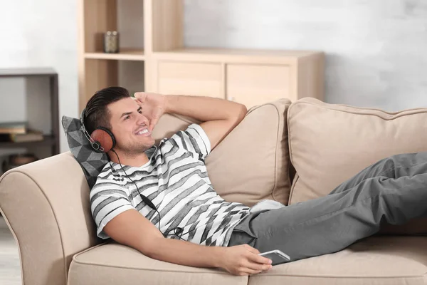 Kjekken Mann Som Hører Musikk Mens Han Hviler Sofaen Hjemme – stockfoto