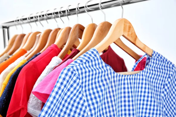 Colorful clothes on hangers in wardrobe — Stock Photo, Image