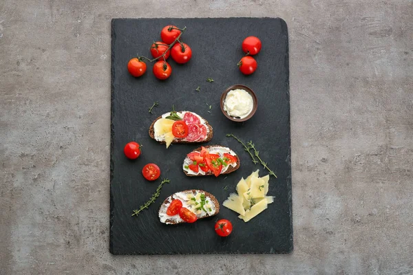 Placa Pizarra Con Deliciosos Bruschettas Sobre Fondo Gris —  Fotos de Stock