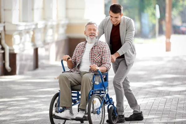 Giovane Caregiver Piedi Con Uomo Anziano All Aperto — Foto Stock