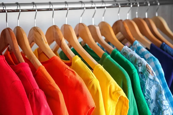 Kolorowe ubrania na wieszakach w szafie — Zdjęcie stockowe