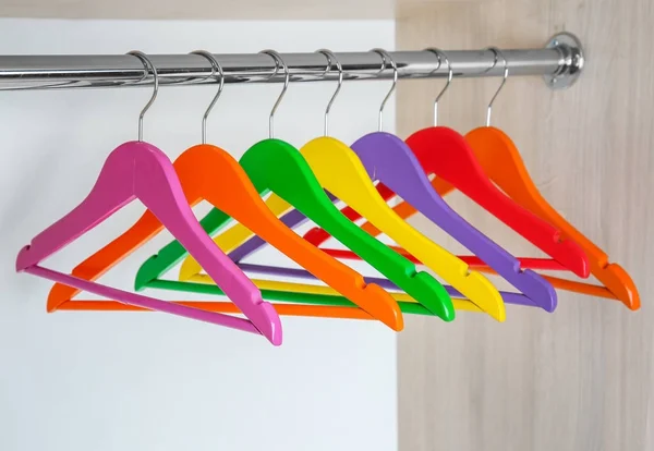 Colgadores de ropa de colores en el armario vacío —  Fotos de Stock