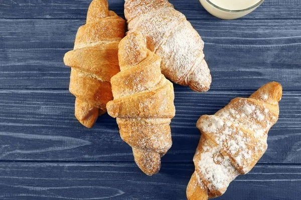 Tasty croissants on wooden background — Stock Photo, Image