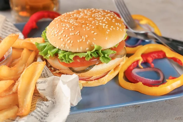 Plate with tasty double burger on table