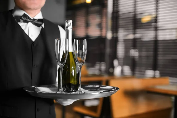 Servitören Holding Bricka Med Flaska Champagne Och Glas Inomhus — Stockfoto