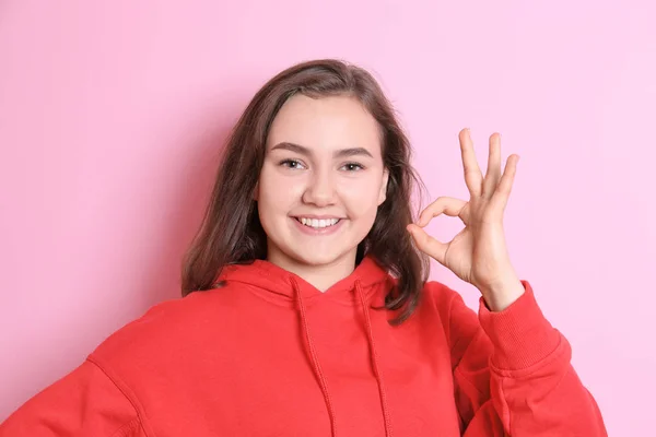 Hermosa mujer sonriente mostrando gesto OK sobre fondo de color —  Fotos de Stock