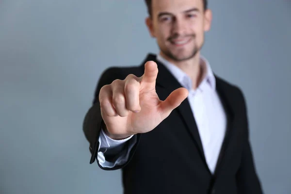 Schöner Mann Formellen Anzug Berührt Unsichtbaren Bildschirm Auf Grauem Hintergrund — Stockfoto