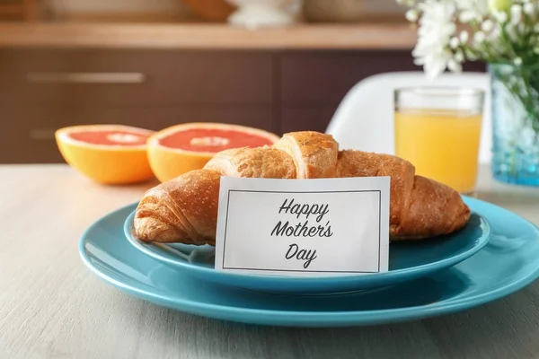 Croissant and card with text HAPPY MOTHER\'S DAY on table