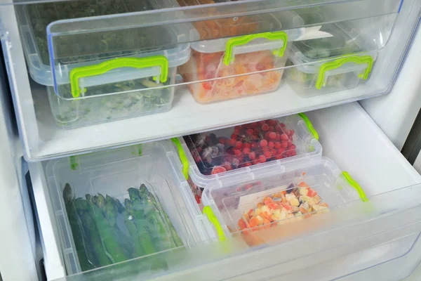 Containers with products in freezer, closeup