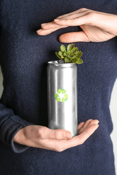 Woman holding tin can with plant, closeup. Waste recycling concept