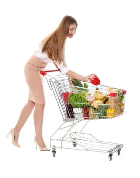 Jonge vrouw met volledige winkelwagentje op witte achtergrond — Stockfoto