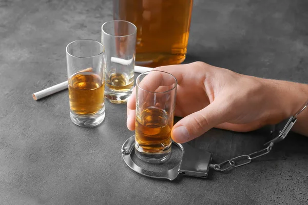 Mann Handschellen Sitzt Mit Zigaretten Und Glas Alkohol Tisch Nahaufnahme — Stockfoto