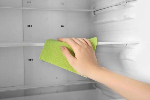 Mujer limpiando refrigerador con trapo, primer plano — Foto de Stock