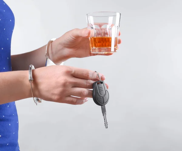Γυναίκα Χειροπέδες Ποτήρι Αλκοόλ Και Αυτοκίνητο Κλειδί Ενάντια Ανοιχτόχρωμο Φόντο — Φωτογραφία Αρχείου
