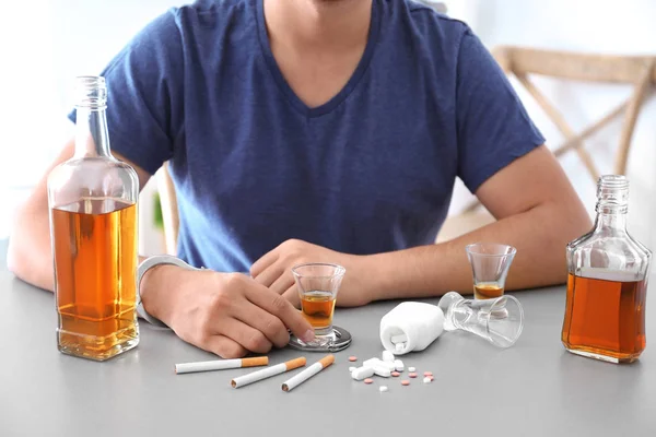 Mann Handschellen Sitzt Mit Zigaretten Drogen Und Einem Glas Alkohol — Stockfoto