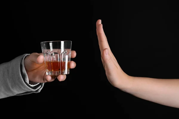 暗い背景にアルコールのガラスを拒否する女性の手 — ストック写真
