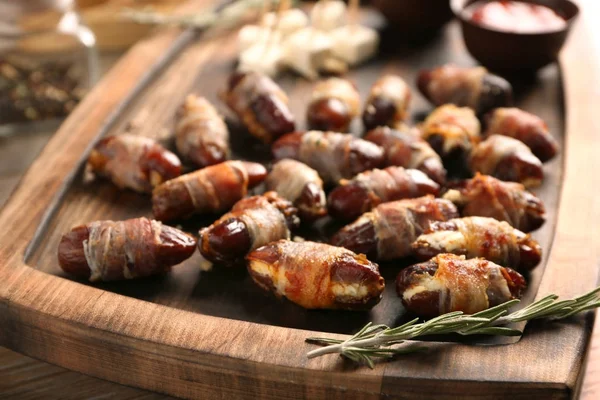 Bandeja de madeira com bacon embrulhado datas, close-up — Fotografia de Stock