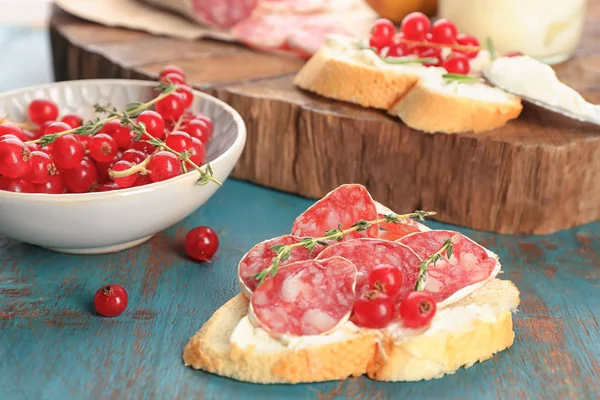赤スグリとテーブル クローズ アップのサラミ美味しいブルスケッタ — ストック写真