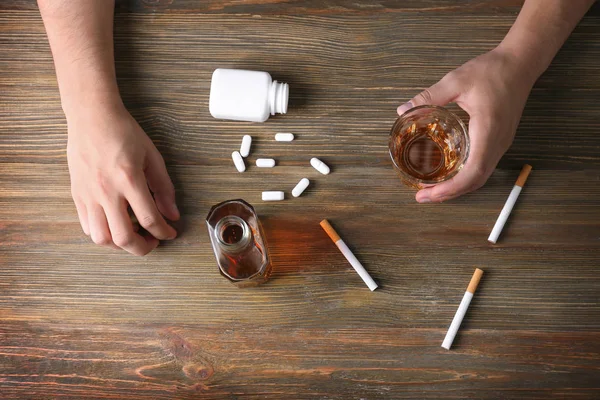 Hombre Sentado Mesa Con Cigarrillos Drogas Alcohol Mesa Madera Concepto — Foto de Stock