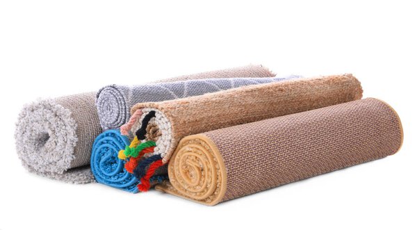 Rolled colorful carpets on white background
