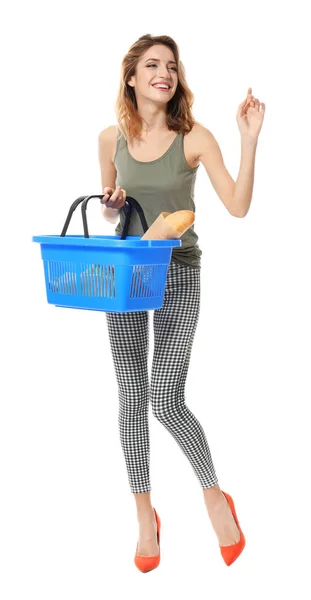 Young woman holding shopping basket with groceries on white background — Stock Photo, Image