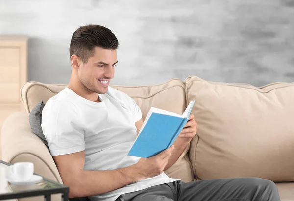 Bonito Homem Lendo Livro Enquanto Descansa Sofá Casa — Fotografia de Stock