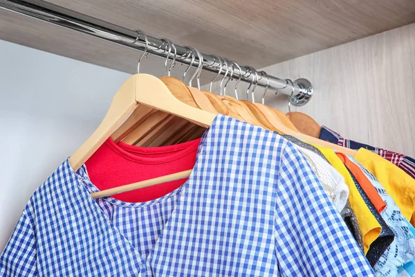 Kleurrijke kleding op hangers in garderobe — Stockfoto